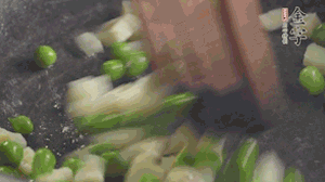 鍋中油7成熱時(shí)，入青豆、筍丁翻炒，然后加糯米飯加鹽均勻翻炒。