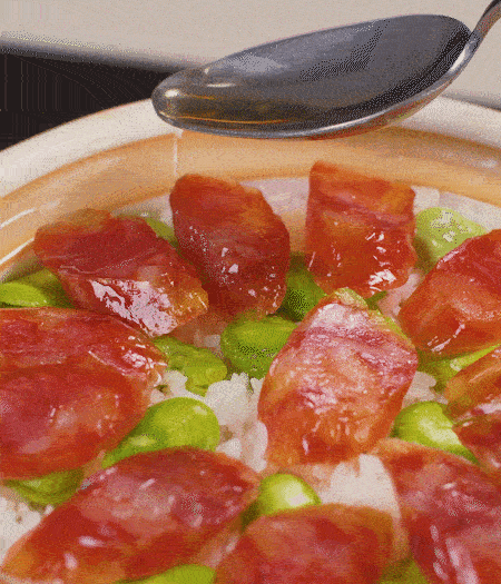 大米出現(xiàn)小孔時(shí)開蓋放香腸，往鍋邊淋入少許油，再燜煮8~10分鐘左右。